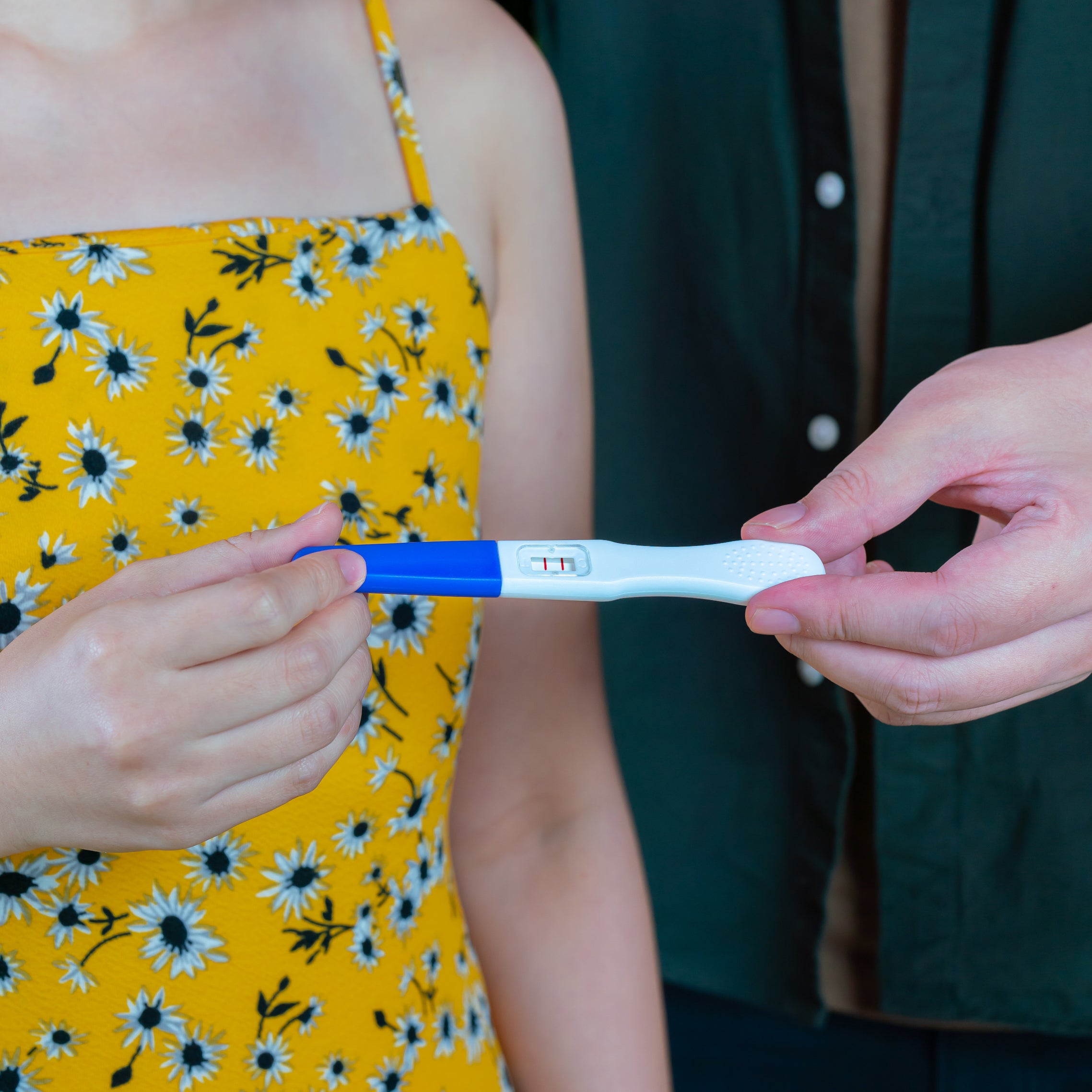 woman holds positive pregnancy test twoplus Fertility