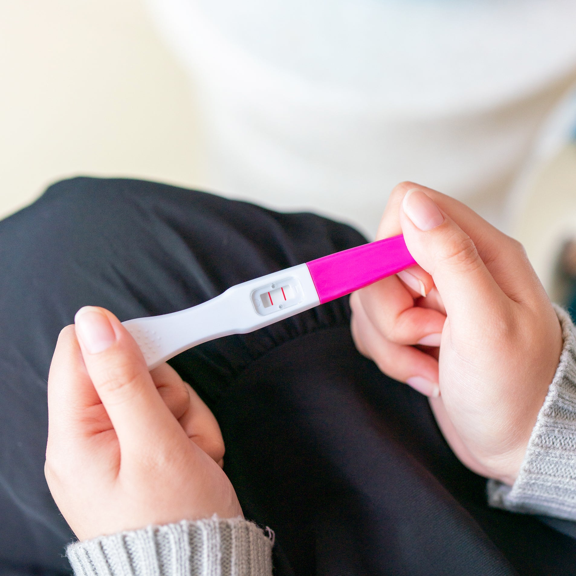 woman holds twoplus Ovulation Test Kit for ovulation tracking