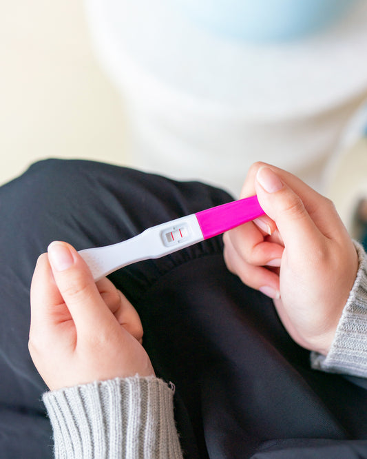 woman holds twoplus Ovulation Test Kit for ovulation tracking